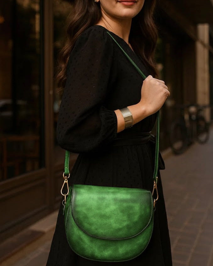 Woman holding a green leather bag in an urban setting