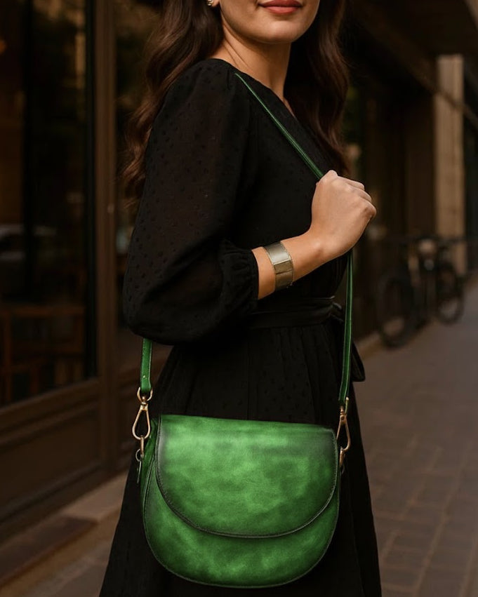 Woman holding a green leather bag in an urban setting